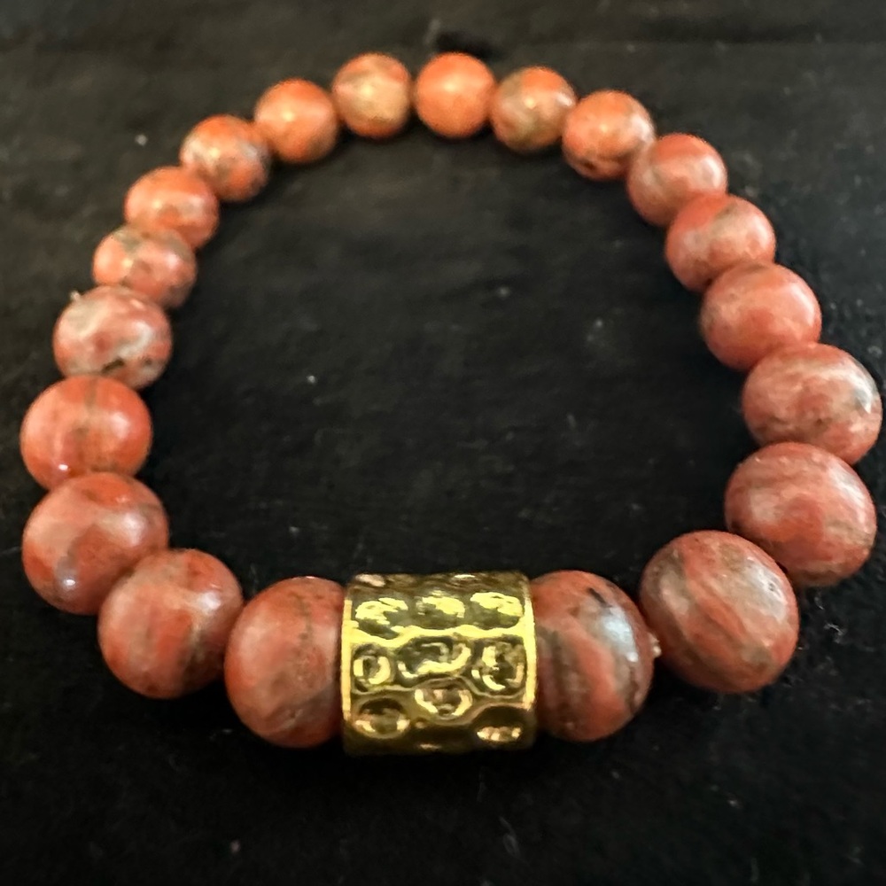 Women’s stretch orange and black stone beaded and gold colored bracelet.